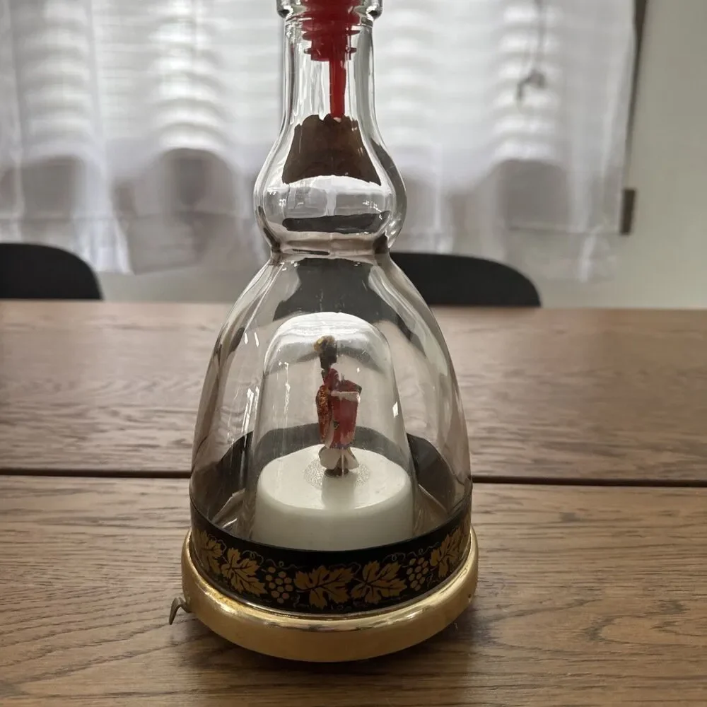 vintage Lucas Bols musical liqueur bottle featuring a  rotating geisha Inside